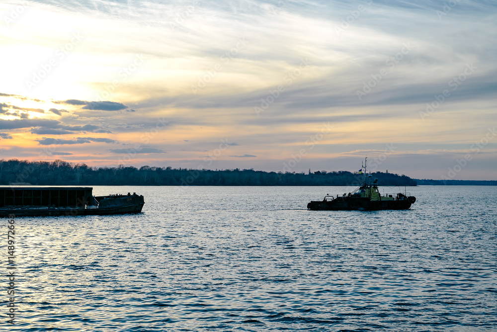 Obraz premium The tug pulls the barge 