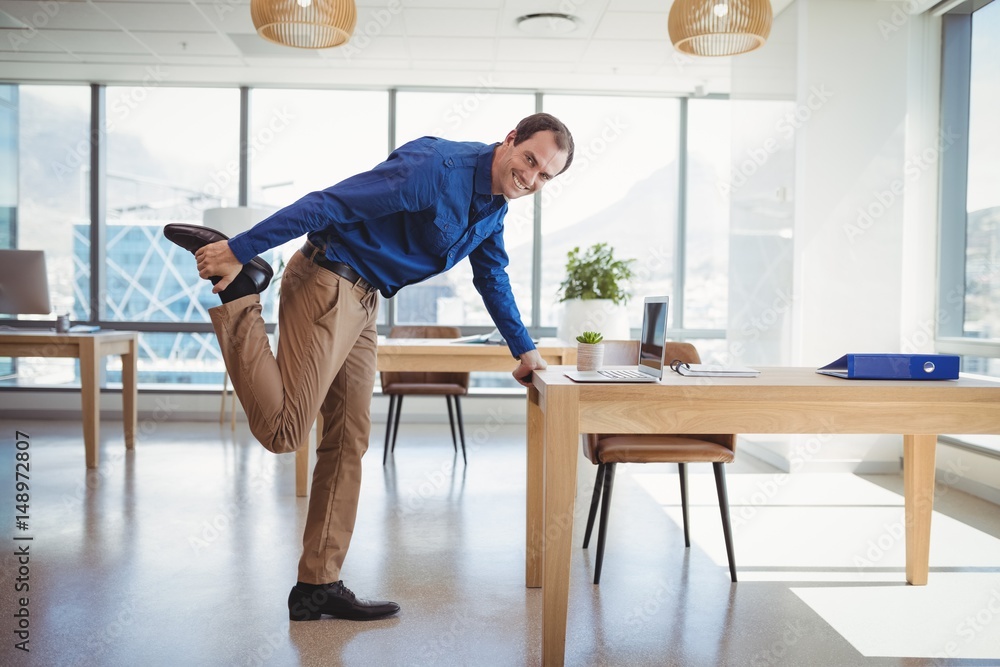 Smiling executive exercising in office