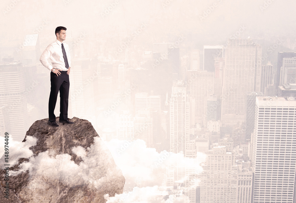Happy businessman standing on stone top Happy businessman standing on stone top