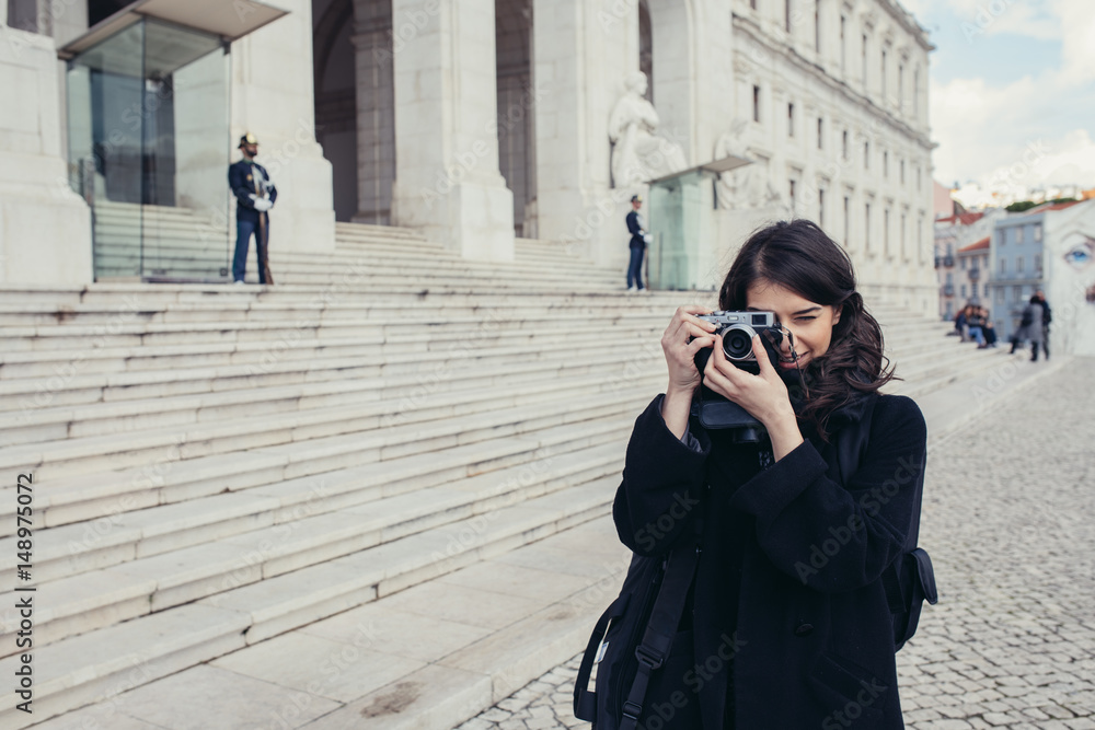 Female tourist photographer making some travel photos of Assembleia da Republica in Lisbon.Smiling is woman admiring watching monumental building of Parliament in Portugal 
