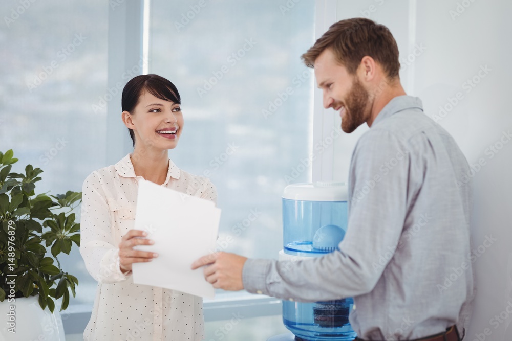 Smiling colleagues discussing over document Smiling colleagues discussing over document