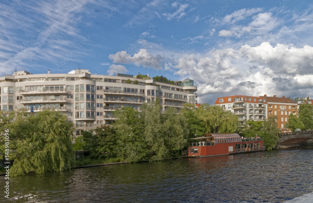 Berlin, Germany - Modern facades of buildings and Old, historic bridge over the river.