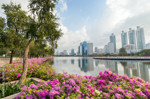 Blooming flowerbeds at the Benjakiti (Benjakitti) Park and modern skyscrapers in Bangkok, Thailand.
