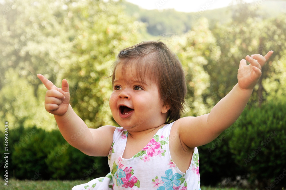 Baby Girl In Summer Dress playing in the park. Baby Girl In Summer Dress playing in the park.