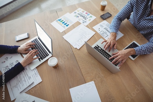 Executives using laptop at desk