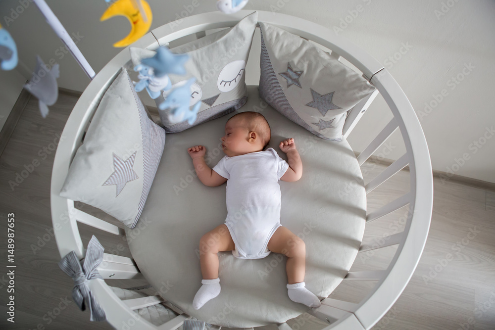 baby boy white t-shirt sleeping in a round bed