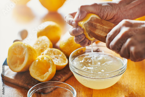 Fotografia woman's hand squeezing juice from a lemon with wooden tool