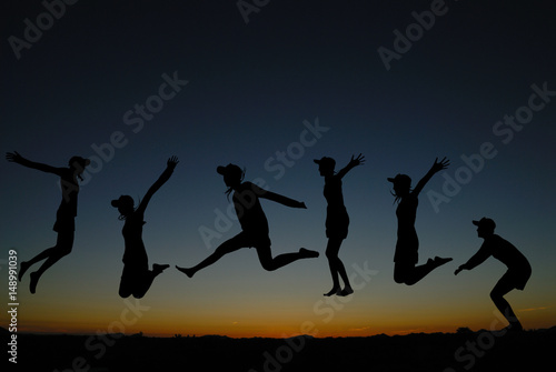 silhouette of people jumping at sunrise