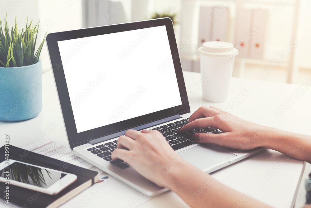 Woman s hands typing on laptop with blank screen Woman s hands typing on laptop with blank screen