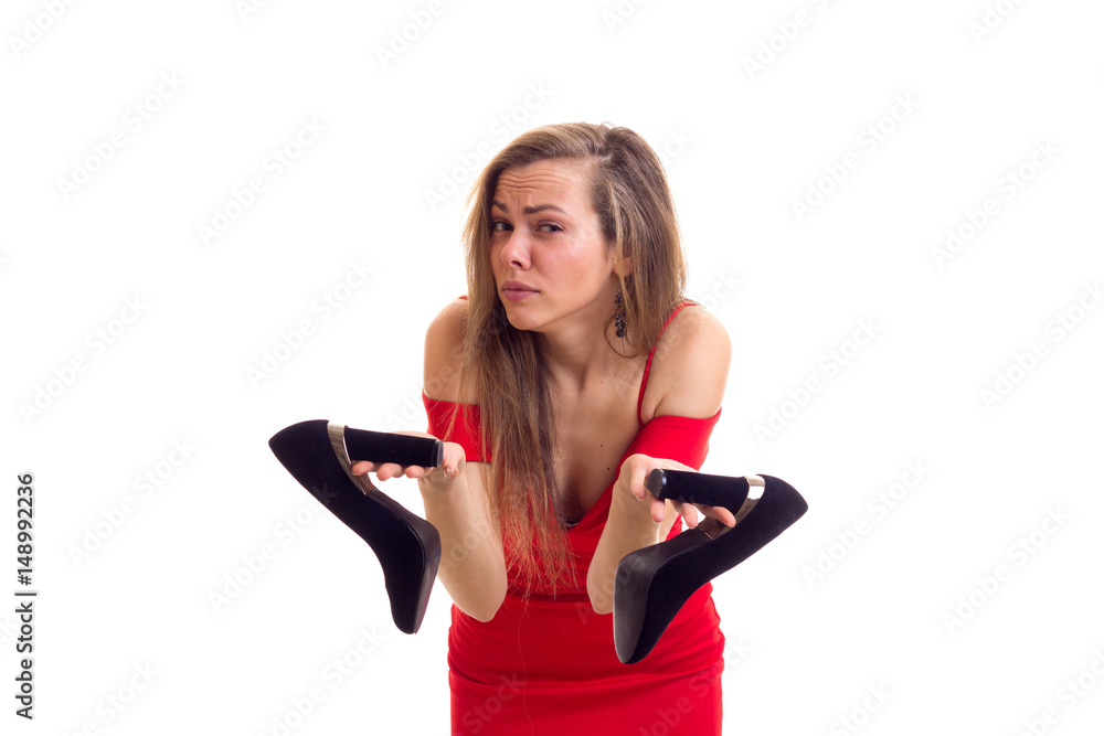 Young woman in red dress holding shoes Young woman in red dress holding shoes