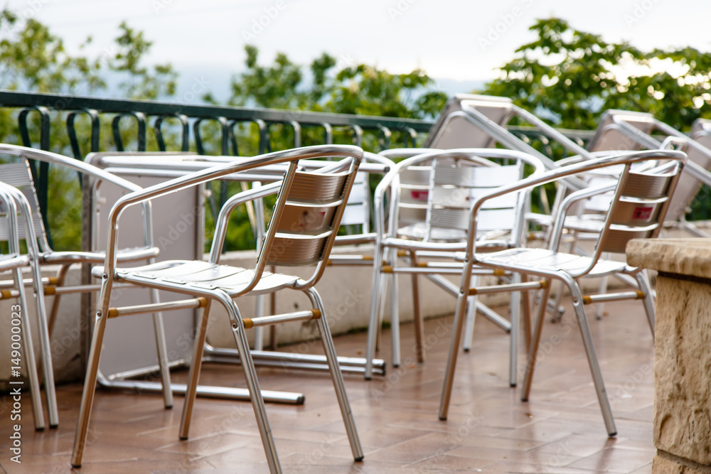 Metal  Aluminum desks and tables in a cafe after rain. Deserted.