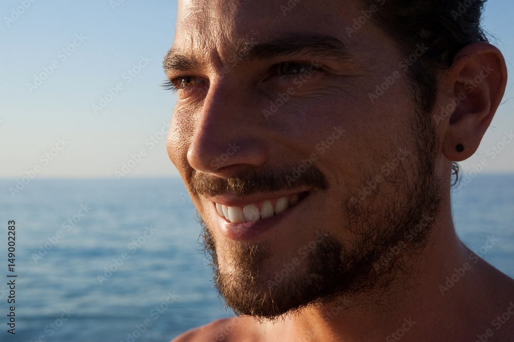 Close up of smiling man looking away at beach Close up of smiling man looking away at beach