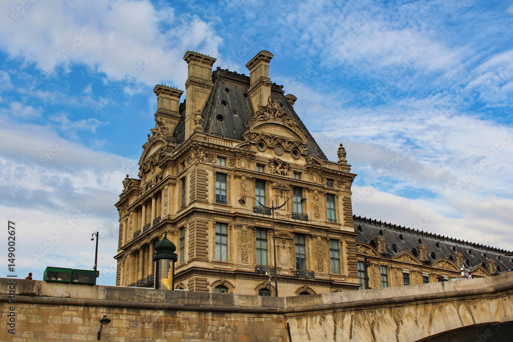 View on Louvre museum building, blue sky with white clouds, paris city, france