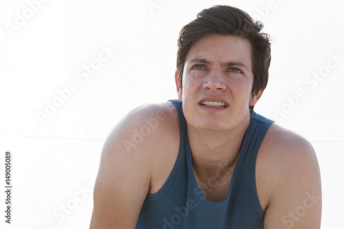Exhausted man taking a break after jogging on beach