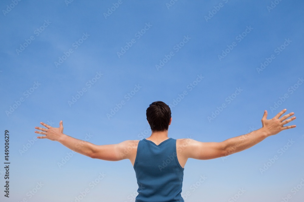 Man standing at beach with arms outstretched Man standing at beach with arms outstretched