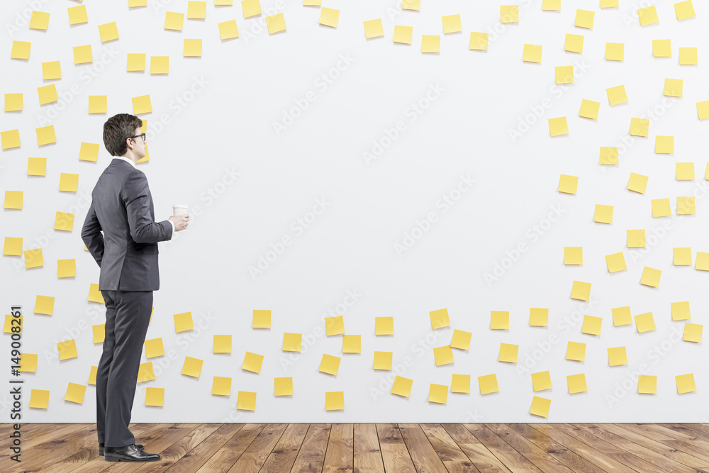 Man with coffee in sticky notes room Man with coffee in sticky notes room