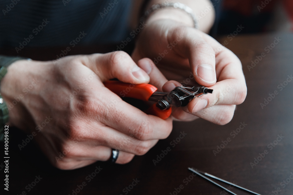 Fototapeta premium male master installs a coyle. Spiral for electronic evaporator and cigarette. Vape, vaping