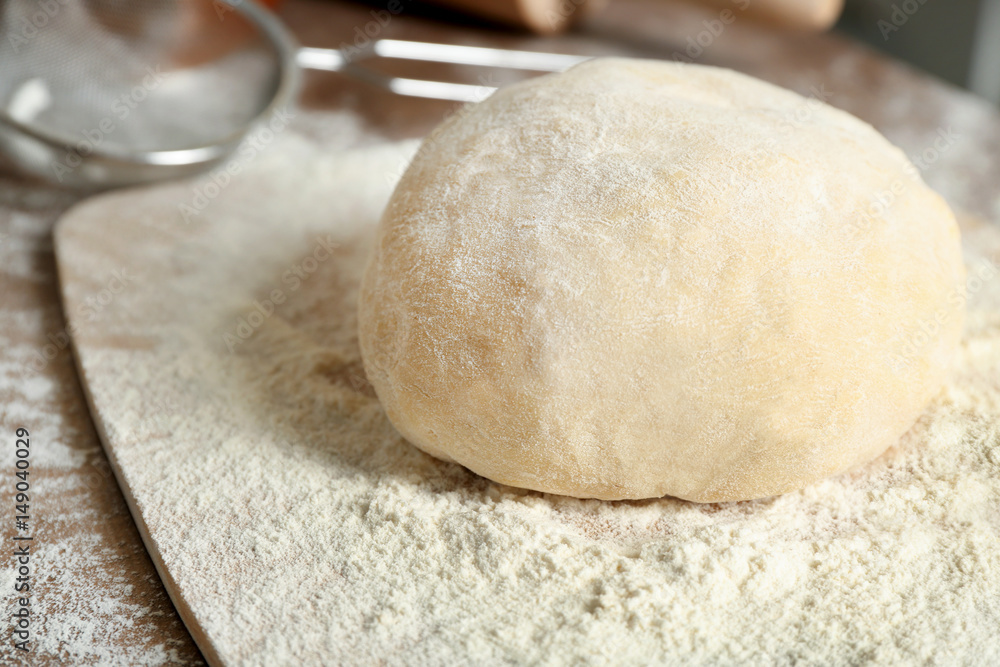 Board with raw dough on kitchen table, closeup Board with raw dough on kitchen table, closeup