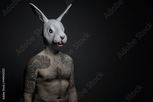 Uomo tatuato con maschera di coniglio photo