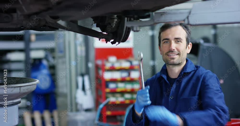 Specialist auto mechanic in the car service, repairs the car, makes transmission and wheels. Concept: repair of machines, fault diagnosis, repair specialist, technical maintenance, on-board computer. Specialist auto mechanic in the car service, repairs the car, makes transmission and wheels. Concept: repair of machines, fault diagnosis, repair specialist, technical maintenance, on-board computer.
