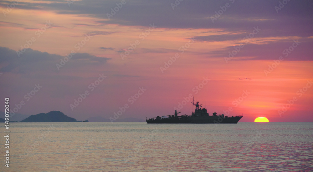 Silhouette of big ship on the ocean at nightfall with orange sunset at the background combined with a cloudy sky, Labuan Bajo, Bajawa.