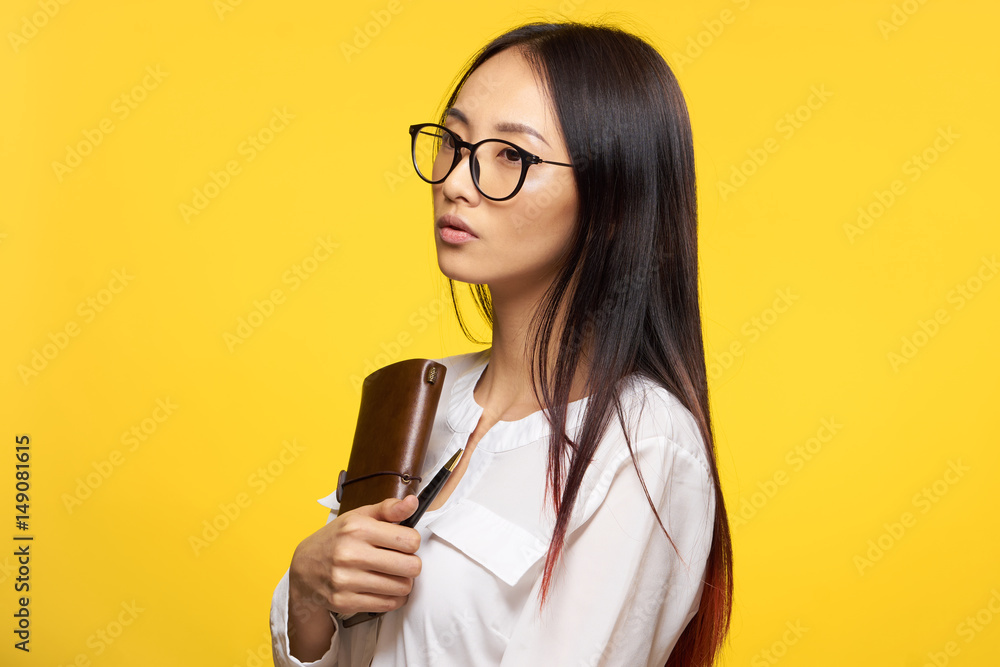 beautiful woman with a notebook on a yellow background, teacher beautiful woman with a notebook on a yellow background, teacher