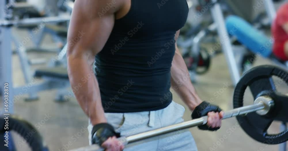 Guy bodybuilder in the gym, works with a barbell, bench press, improving triceps, large pectorals muscle, anterior deltoids muscle Concept love sports, go to the gym, eat right, slim body, be healthy. Guy bodybuilder in the gym, works with a barbell, bench press, improving triceps, large pectorals muscle, anterior deltoids muscle Concept love sports, go to the gym, eat right, slim body, be healthy.
