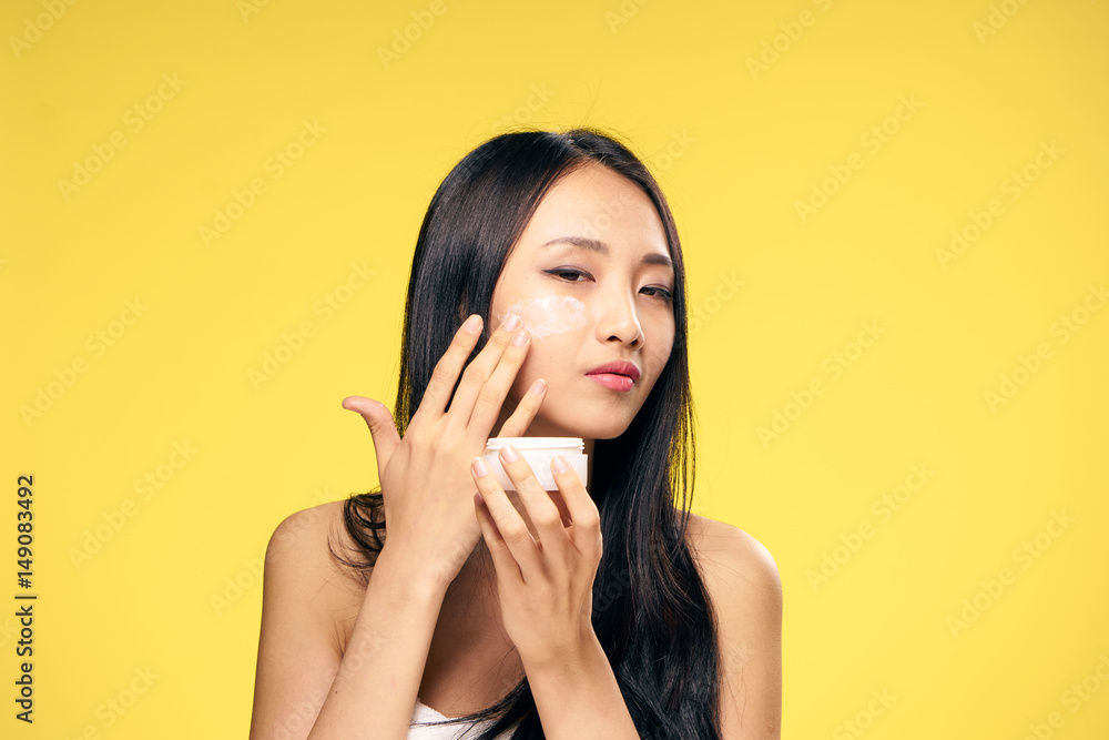 cream in a light jar, young woman in a white towel cream in a light jar, young woman in a white towel