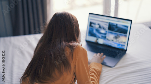 woman lies on the bed watching news on the Internet