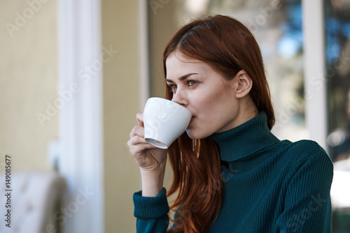 woman drinking coffee on the balcony