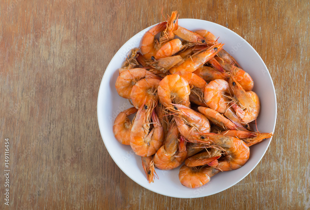 Shrimp baked without sauce in white dish on wooden background Shrimp baked without sauce in white dish on wooden background