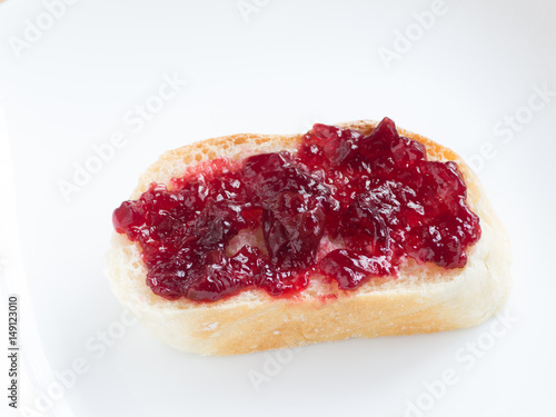 Piece of french bread with cherry jam