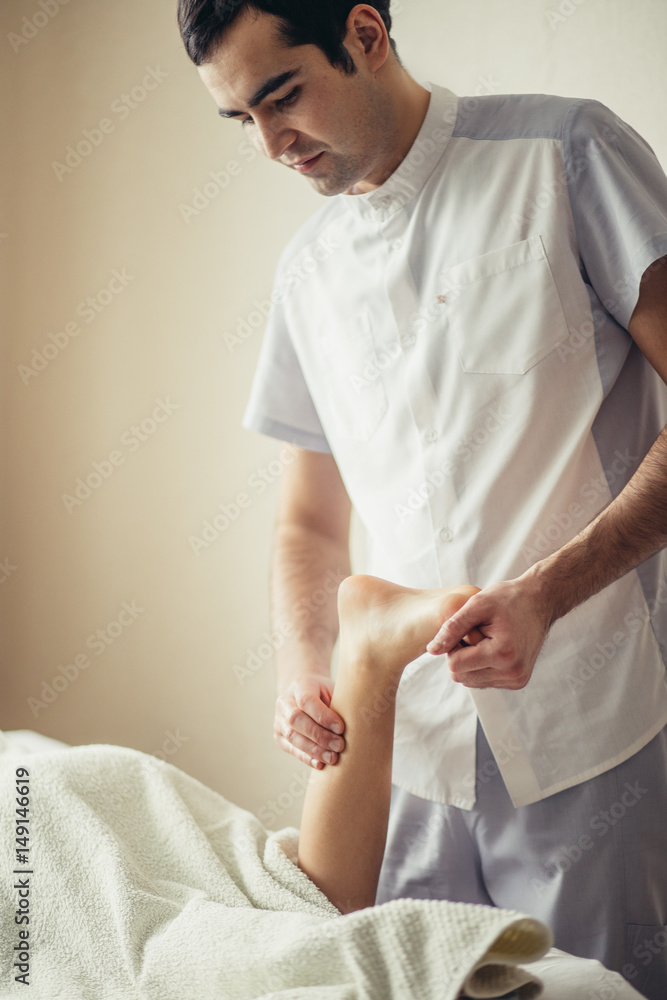 Fototapeta premium Physical Therapist giving a leg massage for little girl