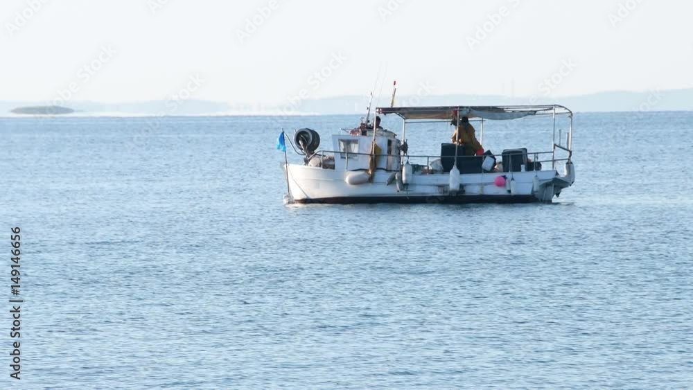 Local fisherman on small boat in the Mediterranean laying nets in sunrise to supply fresh fish to fish markets and restaurants. Local fisherman on small boat in the Mediterranean laying nets in sunrise to supply fresh fish to fish markets and restaurants.