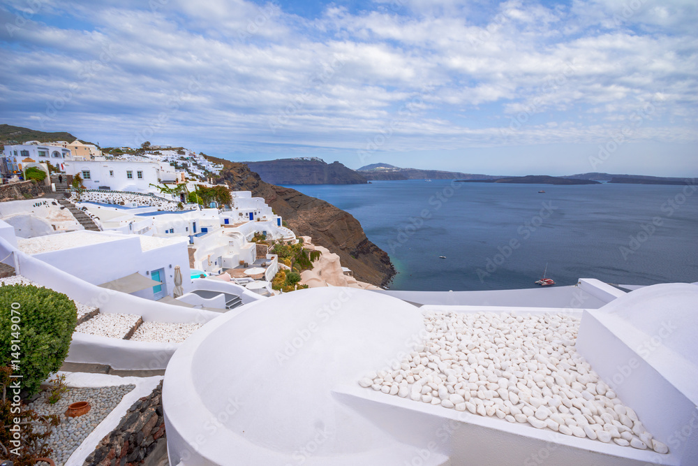 Obraz premium Oia town on Santorini island, Greece. Traditional and famous houses and churches with blue domes over the Caldera, Aegean sea