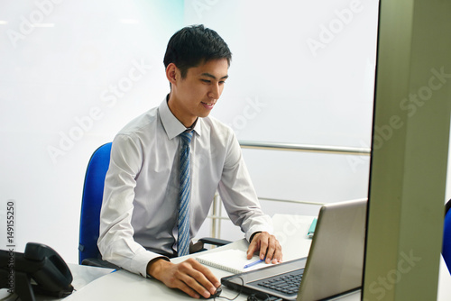 Kazakh young man office worker at the table talking on the phone