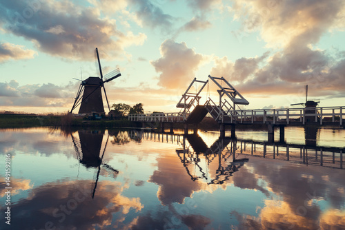Photography Landscape with tulips, traditional dutch windmills and houses near the canal in Zaanse Schans, Netherlands, Europe