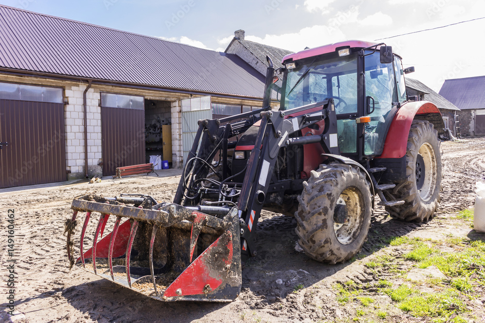 Naklejka premium Agricultural machinery and equipment . Tractor with front loader for manure. The yard of a dairy farm. Podlaskie, Poland.