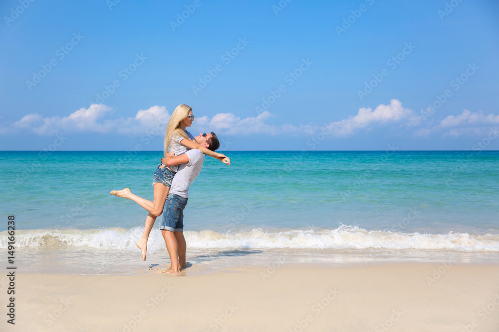 Young happy couple on beach smiling holding around each other. Love story Young happy couple on beach smiling holding around each other. Love story
