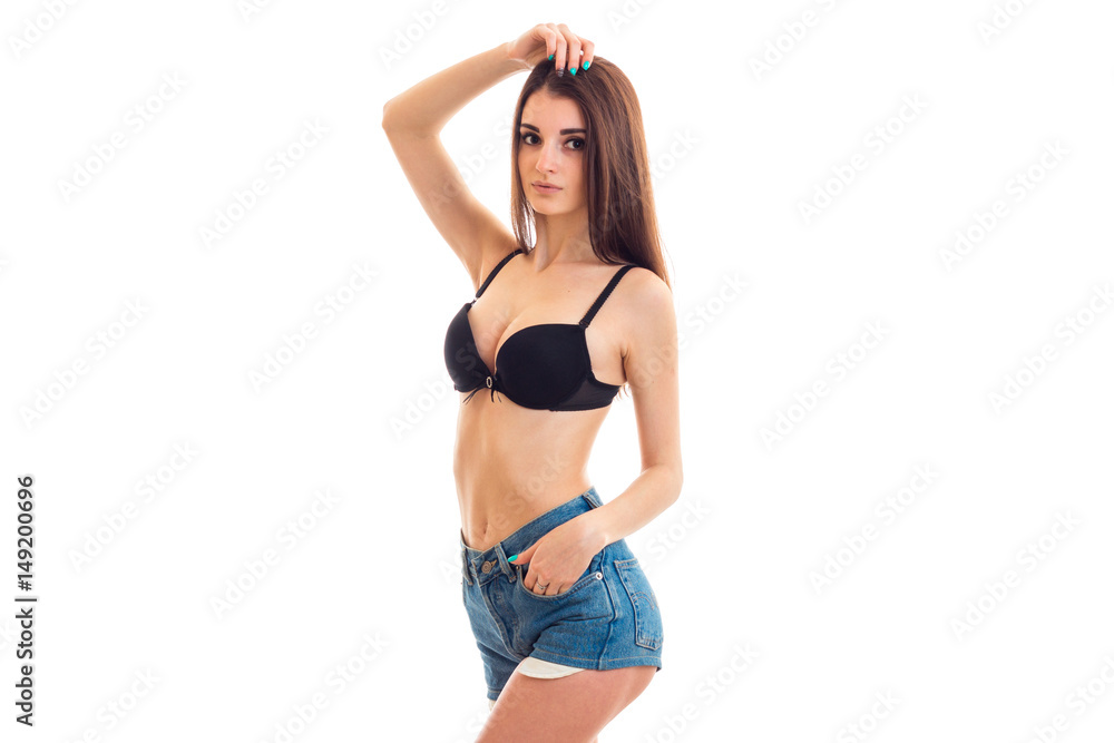young beautiful girl standing in shorts and bra and holds her hand near the head young beautiful girl standing in shorts and bra and holds her hand near the head