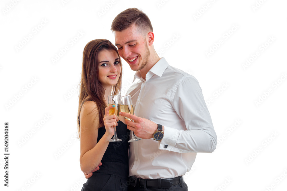 young loving guy with a girl standing near and carrying champagne glasses young loving guy with a girl standing near and carrying champagne glasses