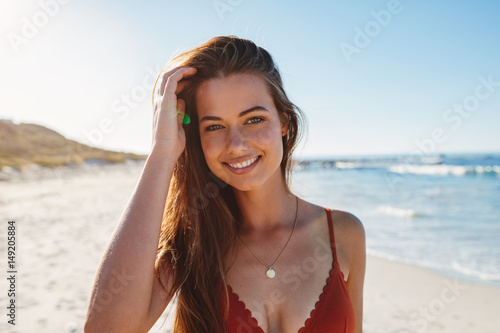Charming young woman in bikini on the beach photo