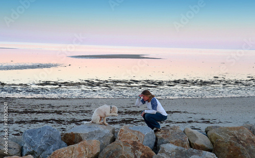 Frau mit Hund am Strand – Hund zeigt einen Trick 