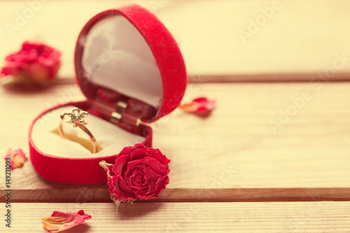 Golden engagement ring in a heart shaped box photo
