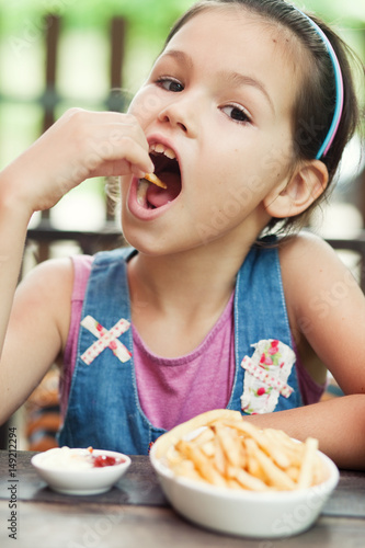 Little girl eating french fries 