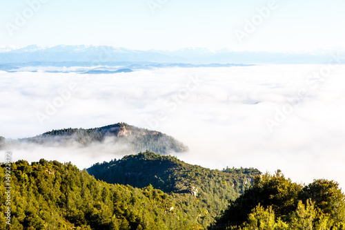 Clouds in the mountains lit by the sun. The view from the top.