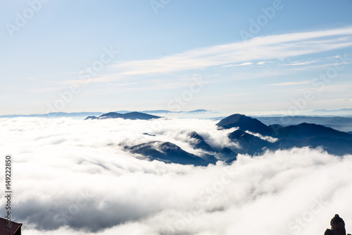Clouds in the mountains lit by the sun. The view from the top. © milanchikov