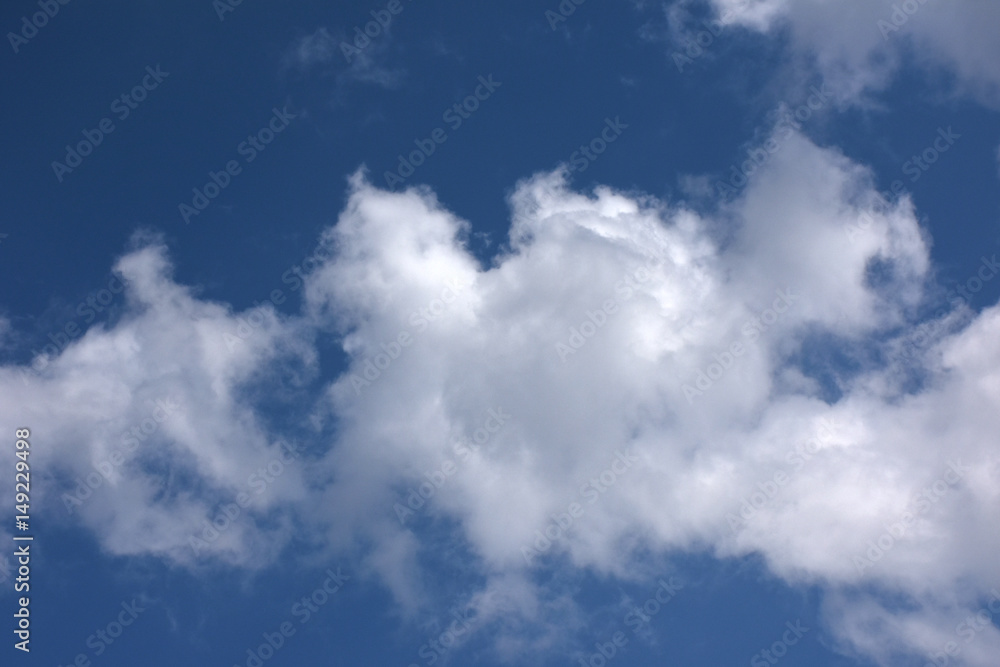青空と雲「空想・じゃれあう雲のモンスターたち（左のモンスターが口を大きくあけ、真ん中のモンスター（犬）がちょっかいをかけているイメージ）」仲間、元気、じゃれあうなどのイメージ