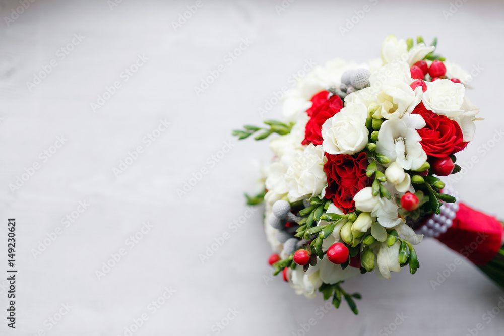bridal bouquet close up. red and white roses, freesia, brunia decorated in composition