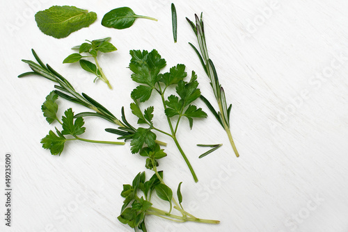 Green fresh herbs mix on white wooden background , top view 